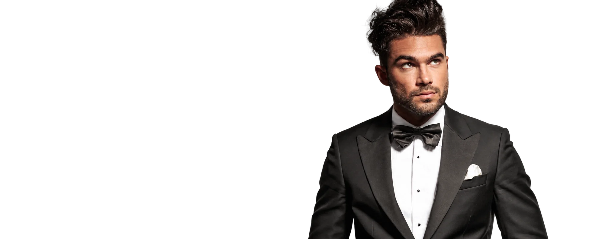 Un homme barbu aux cheveux coiffés en arrière porte un smoking noir, un nœud papillon et une pochette blanche.